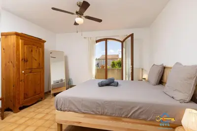 a bedroom with a large bed with a ceiling fan at Maison Jade - Villa avec piscine - Barbecue - Calme in Narbonne
