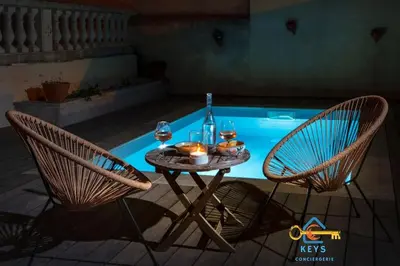 a table and two chairs next to a swimming pool at Maison Jade - Villa avec piscine - Barbecue - Calme in Narbonne