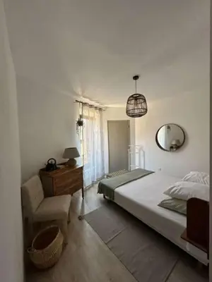 a bedroom with a bed and a chair and a mirror at La Pause Bonheur - L'occitane in Luc-sur-Orbieu