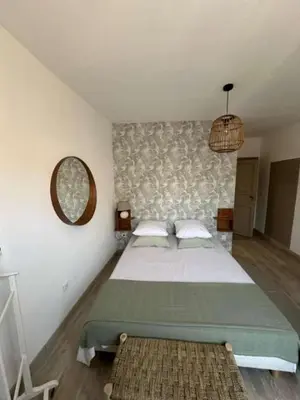 a bedroom with a large bed and a mirror at La Pause Bonheur - L'occitane in Luc-sur-Orbieu