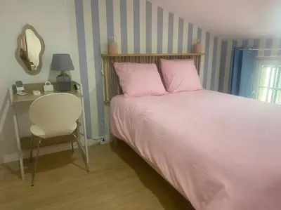a bedroom with a bed with pink pillows and a desk at Le grand Castel in Castelnaudary