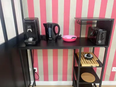 a black table with a microwave and a coffee maker on it at Le grand Castel in Castelnaudary