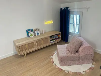 a living room with a chair and a table at Le grand Castel in Castelnaudary