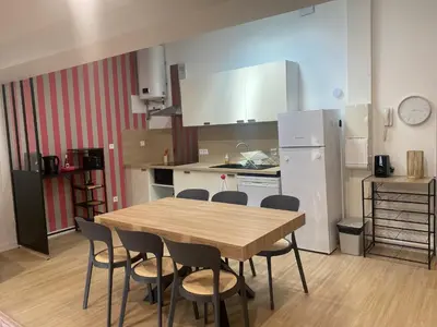 a kitchen with a wooden table and chairs in it at Le grand Castel in Castelnaudary