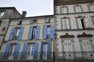 a building with blue shutters on the side of it at Le grand Castel in Castelnaudary
