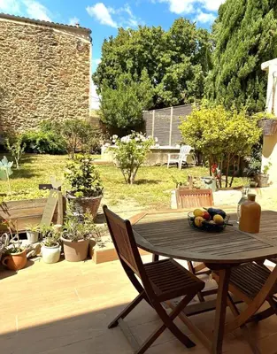 a wooden table and chairs on a patio at La Pause Bonheur - La Vagabonde in Luc-sur-Orbieu