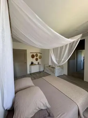 a bedroom with a large bed with a canopy at La Pause Bonheur - La Vagabonde in Luc-sur-Orbieu