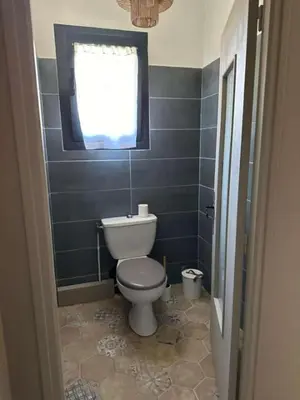 a bathroom with a toilet and a window at La Pause Bonheur - La Vagabonde in Luc-sur-Orbieu