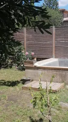 a garden with a wooden deck with some flowers at La Pause Bonheur - La Vagabonde in Luc-sur-Orbieu