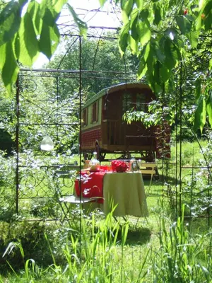 a red bus in a cage with a table at La Hulotte in Mazamet
