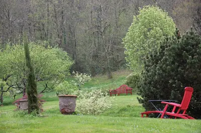 two red chairs sitting in the grass in a park at La Hulotte in Mazamet