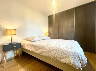 a bedroom with a bed and a night stand with a lamp at 147 - Vue Cité Médiévale et Parking in Carcassonne