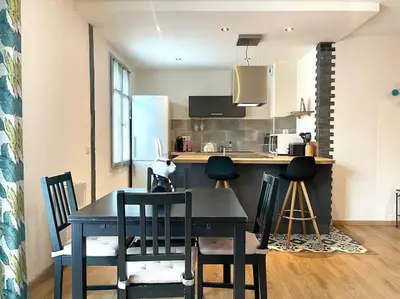 a kitchen with a table and chairs in a room at 147 - Vue Cité Médiévale et Parking in Carcassonne