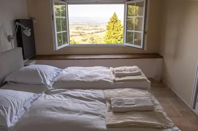 two beds in a room with a window at Les Deux Petits Pois in Fanjeaux