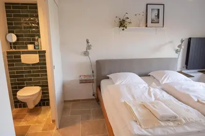 a small bedroom with a bed and a toilet at Les Deux Petits Pois in Fanjeaux