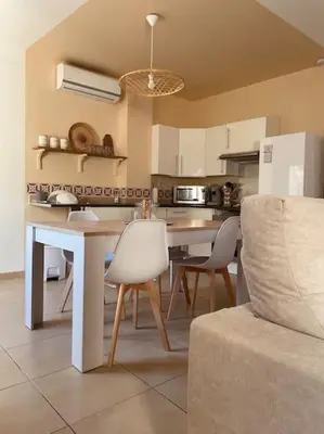a kitchen with a table and chairs and a couch at T2 refait à neuf Calme et agréable in Narbonne