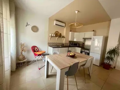 a kitchen with a table and chairs in a kitchen at T2 refait à neuf Calme et agréable in Narbonne