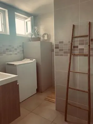a bathroom with a sink and a refrigerator at T2 refait à neuf Calme et agréable in Narbonne
