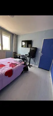 a bedroom with a large bed with red roses on it at Hotel Castres Chambre Simple in Castres