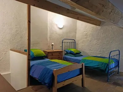 two twin beds in a room with at Gite les Volets Verts in Cesseras