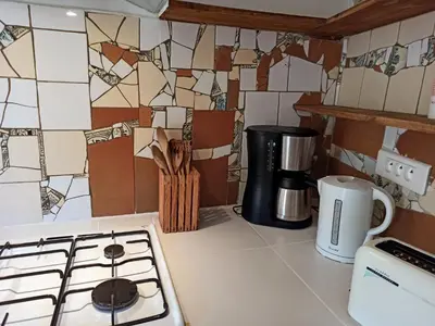 a kitchen counter with a stove and a coffee maker at Gite les Volets Verts in Cesseras