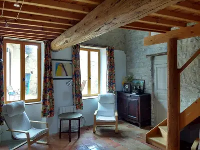 a room with two chairs and a desk and windows at Gite les Volets Verts in Cesseras