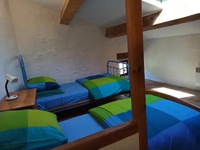 a bedroom with two bunk beds and a desk at Gite les Volets Verts in Cesseras