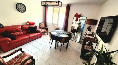 a living room with a red couch and a table at Appartement central avec parking in Carcassone