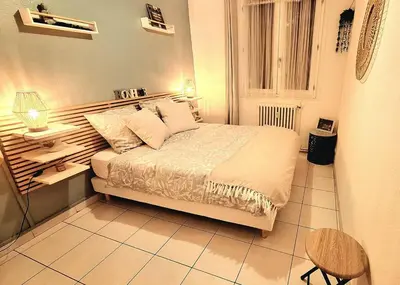 a bedroom with a bed and a table and a chair at Appartement central avec parking in Carcassone
