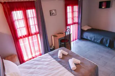 a bedroom with a bed and red curtains at Hôtel du vieux pont in Mazères