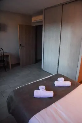 two rolls of towels sitting on top of a bed at Hôtel du vieux pont in Mazères