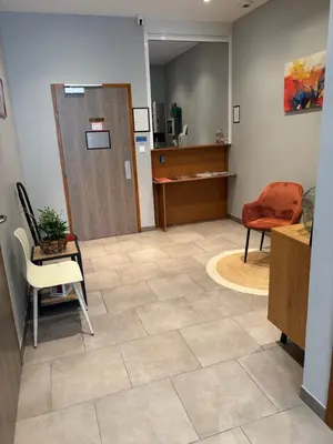 an office with a waiting room with a door and a chair at Hôtel du vieux pont in Mazères