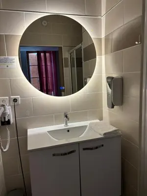 a bathroom with a sink and a mirror at Hôtel du vieux pont in Mazères