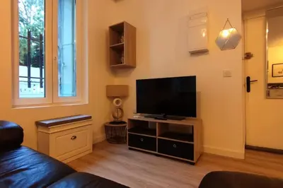 a living room with a flat screen tv on a stand at T2 Cosy - Proche place Verdun in Castelnaudary
