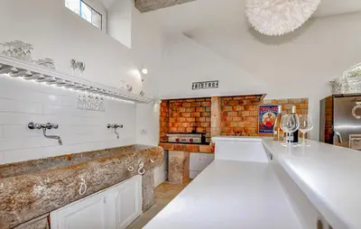 a kitchen with white counters and a brick wall at Lovely Home In Narbonne in Narbonne