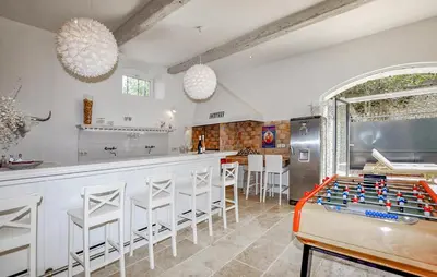 a kitchen with a bar with a table and stools at Lovely Home In Narbonne in Narbonne