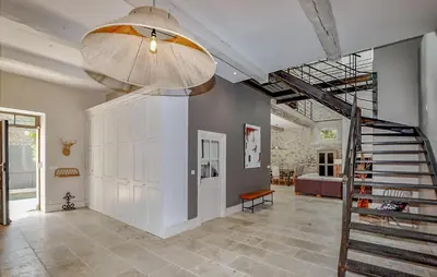 a hallway with a staircase and a living room at Lovely Home In Narbonne in Narbonne