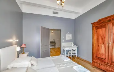 a bedroom with a bed and a table and a desk at Lovely Home In Narbonne in Narbonne