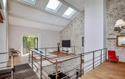 a room with a staircase with a table and a tv at Lovely Home In Narbonne in Narbonne