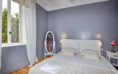 a bedroom with a large white bed and a mirror at Lovely Home In Narbonne in Narbonne
