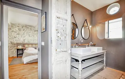 a bathroom with two sinks and a bedroom at Lovely Home In Narbonne in Narbonne
