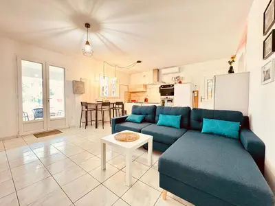 a living room with a blue couch and a table at Maison avec piscine-climatisation-jardin in Ventenac en Minervois