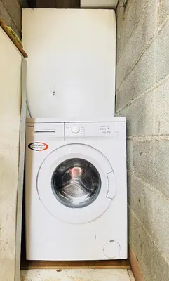 a washer and dryer sitting next to a brick wall at Maison avec piscine-climatisation-jardin in Ventenac en Minervois