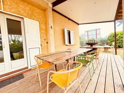 a wooden table and chairs on a deck at Maison avec piscine-climatisation-jardin in Ventenac en Minervois
