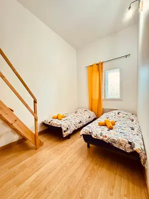 two beds in a room with a staircase at Maison avec piscine-climatisation-jardin in Ventenac en Minervois