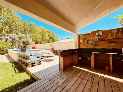 an outdoor deck with a bench and a table at Maison avec piscine-climatisation-jardin in Ventenac en Minervois