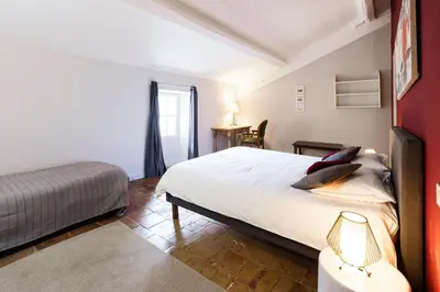 a bedroom with a large white bed and a window at Gîte La Maison des Vendangeurs in Villesèque-des-Corbières