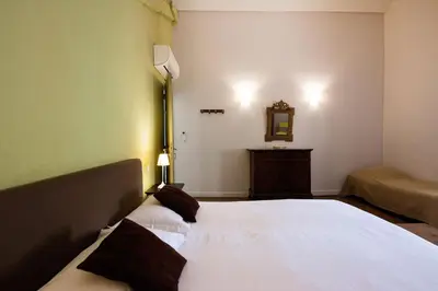 a bedroom with a large white bed and a mirror at Gîte La Maison des Vendangeurs in Villesèque-des-Corbières