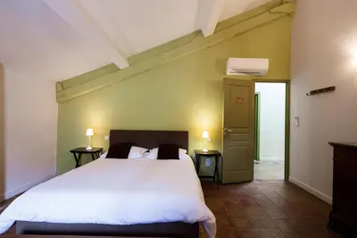 a bedroom with a large white bed with two lamps at Gîte La Maison des Vendangeurs in Villesèque-des-Corbières