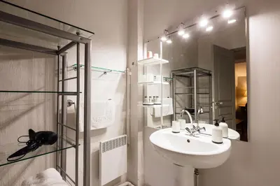 a white bathroom with a sink and a shower at Gîte La Maison des Vendangeurs in Villesèque-des-Corbières